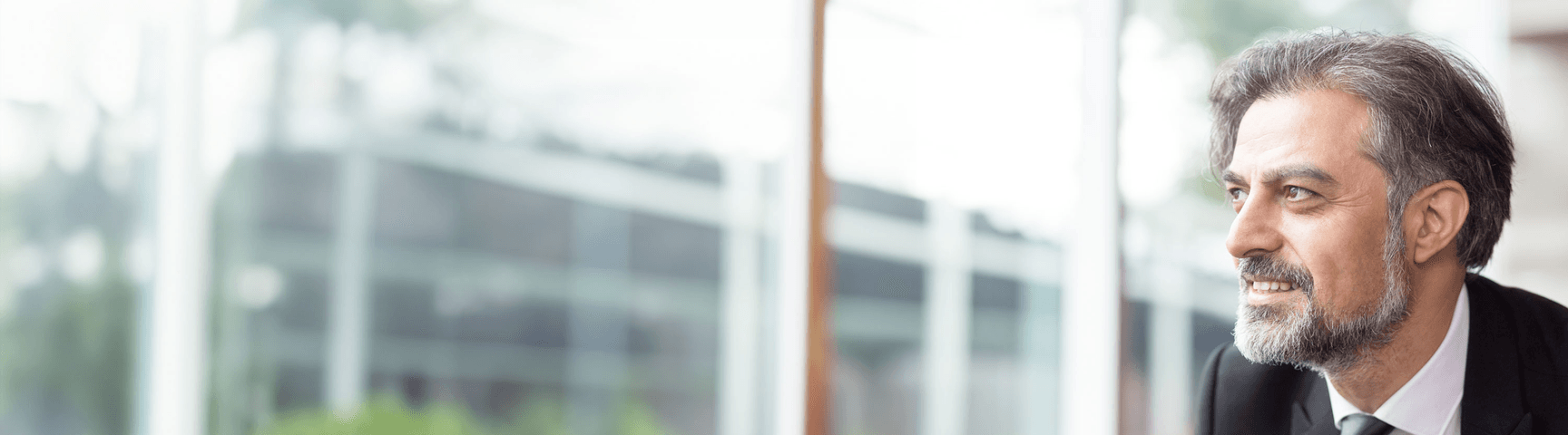 smiling business leader looking through window